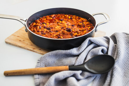 homemade vegetarian tempeh kidney bean chilli with corn in cooking pot