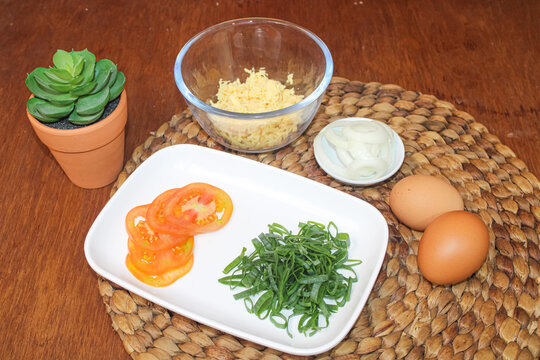 Fresh food prep ingredients tomatoes scallions eggs cheese and onions photo