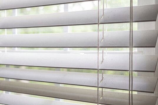 Close up of white window blinds with natural light