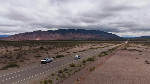 Drone of endless Recta del Tin Tin highway across open desert plain, aerial angled orbit