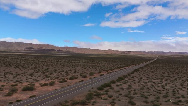 Drone overview of empty road, Recta del Tin Tin through arid desert landscape, aerial