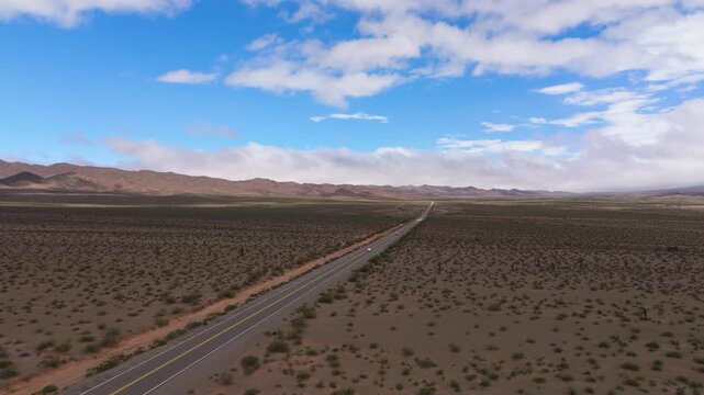 Drone of Recta del Tin Tin highway crossing vast desert plain in Salta, aerial establishing