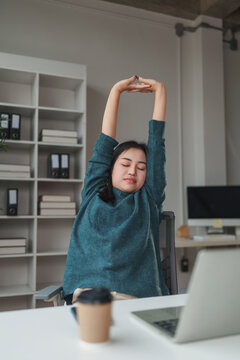 Woman stretching arms overhead for relief from work fatigue