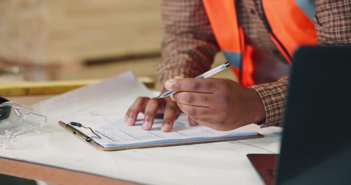 Hands, carpenter or writing with clipboard in warehouse for wood production, inventory or checklist. Person, carpentry or taking notes with documents for timber project, lumber plan or distribution