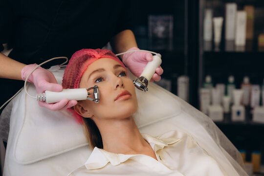 Woman receiving microcurrent facial treatment for skin rejuvenation