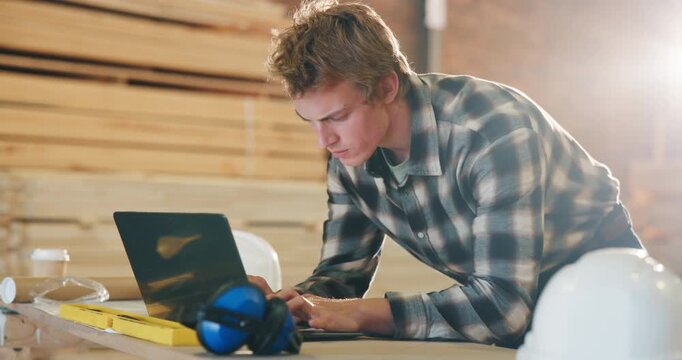 Carpentry, typing and man on laptop in workshop for furniture order, building schedule and email. Carpenter, business and person on computer for planning, report and timber inventory for woodworking