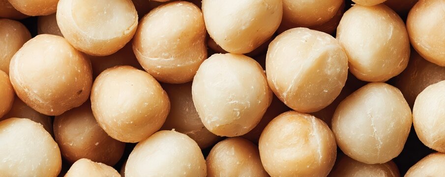 Ultra wide macro of macadamia nuts tightly packed together. Creamy ivory tones and glossy highlights showcase premium food detail and refined texture.