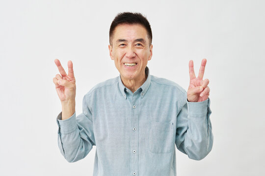 白背景でピースサインの男性