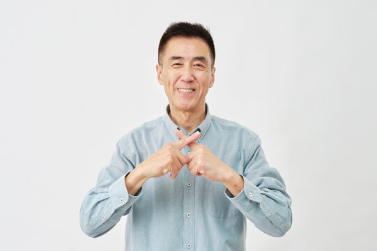 白背景でバツ印のジェスチャーをする男性