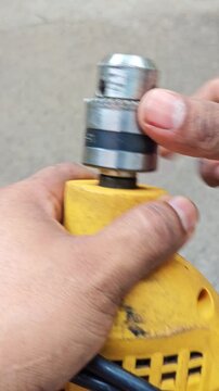 Adjusting Drill Chuck Key on Yellow Power Drill Close Up