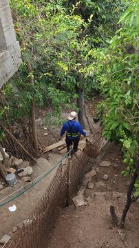 Person Putting On Protective Work Gloves Walking Under Garden Trees