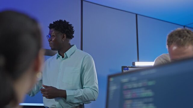 African male developer leads team discussion on workflow development and process optimization, collaborating with colleagues on AI-assisted strategy and team productivity enhancement.