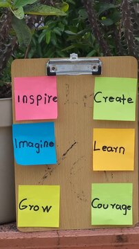 Six Inspirational Sticky Notes Organized on Wooden Base Board