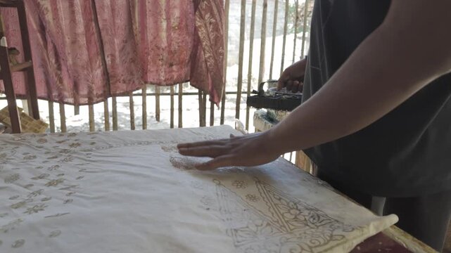 Artisan Hand Stamping Traditional Batik Fabric with Copper Stamp in Indonesia