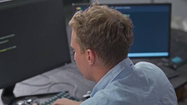 Male developer focuses deeply on advanced coding tasks with syntax highlighting, demonstrating intense concentration and sophisticated programming work.