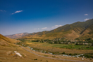 Small village in a green mountain valley. Rural life and nature landscape background. © Aleksandr.Kai