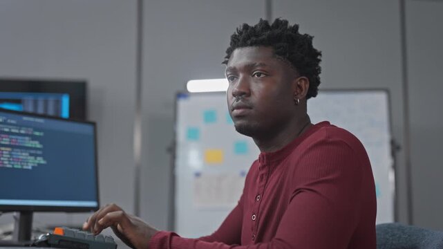 African male developer analyzes workflow and task planning, considering sprint board and project management strategy for optimal execution.