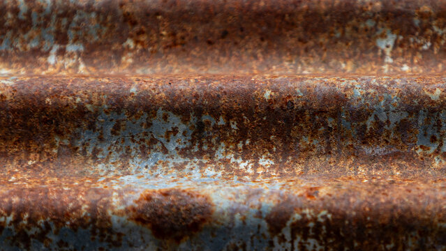 Close up of rustic rusty corrugated metal zinc sheet texture background.A detailed close-up shot of a heavily weathered and rusty corrugated zinc iron sheet. 