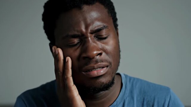 African men hold their faces with one hand and express pain, men's pain expression