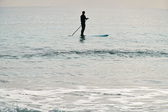 Stand-Up-Paddling im ruhigen Wasser bei D&auml;mmerung (am Mittelmeer)