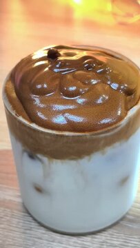 Pour the whipped coffee over the milk glass 