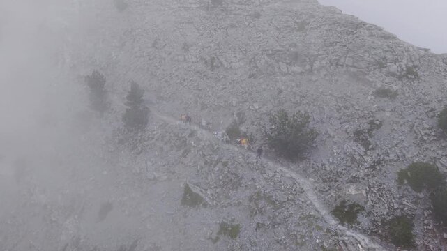 Aerial View of Pack Mules Ascending Rocky Ridge on Mount Olympus in Heavy Fog
