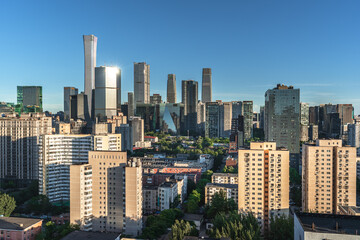 Fototapeta premium Sunlight illuminates the skyline of Beijing's CBD, showcasing the city's vitality.