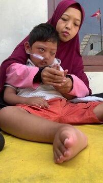 Mother supporting a child with a disability and nasogastric tube in a home care setting