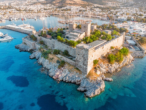 Bodrum Castle standing on a rocky peninsula with turquoise Aegean Sea waters and a busy marina filled with sailboats