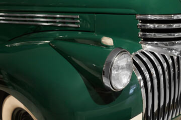 A classic 1940s pickup truck with features a distinctive deep green paint job and a distinctive chrome grille. © SKfoto GE