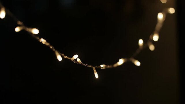 Close-up of flashing string lights at night, with warm yellow string lights flashing against the background