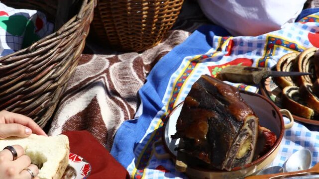 Young girl, woman is having breakfast, taking food to eat at open in retro style, like old times. Health care and food concept in traditional rural meal, homemade dry meat, pickle, bread, harvest time