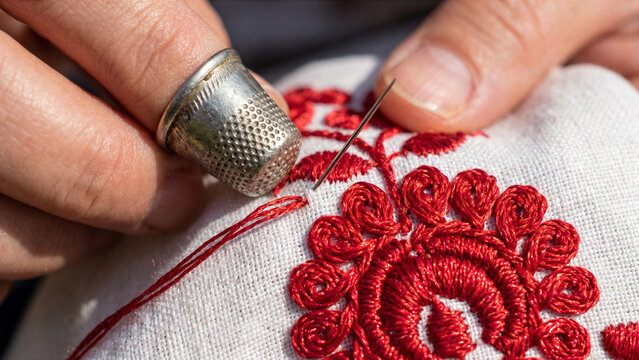 Hungarian embroidery artisan hand stitching red Matyo floral pattern glossy silk thread thimble