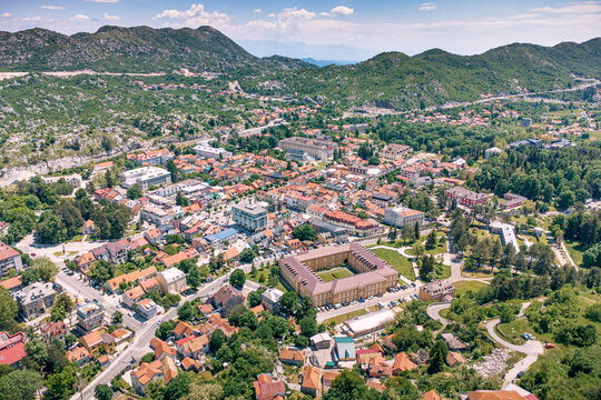 Cetinje, Montenegro, historic royal capital city with buildings and houses among green trees and surrounding mountains