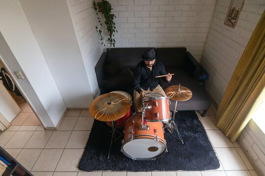 Overhead view of a male musician playing drums at home, top down shot