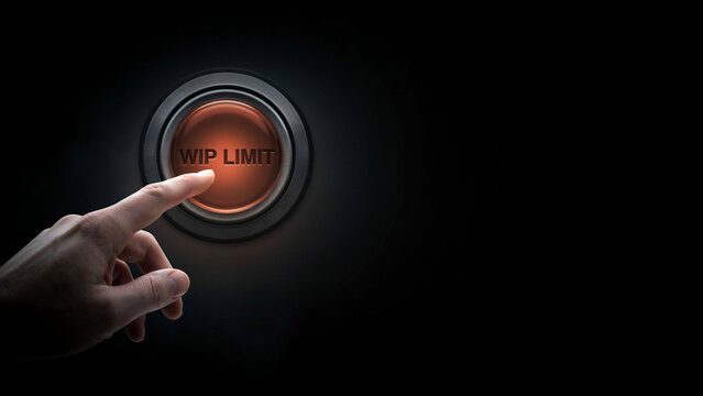 Human finger pressing glowing orange button labeled with work in progress limit concept symbol