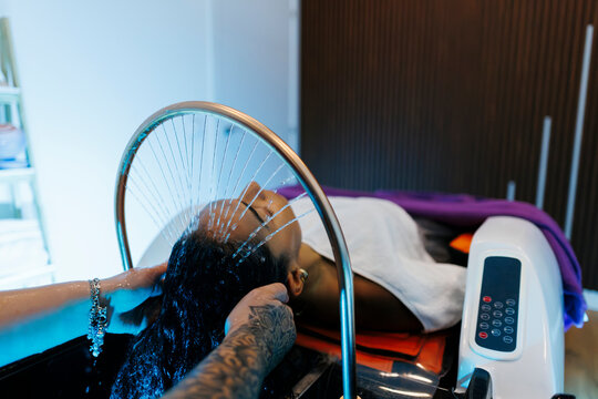 Woman enjoying hair washing treatment in salon spa