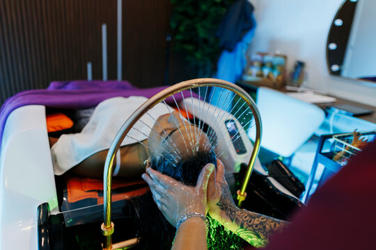 Woman enjoying hair washing treatment in salon