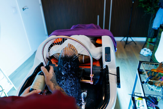 Client receiving professional hair washing treatment in salon