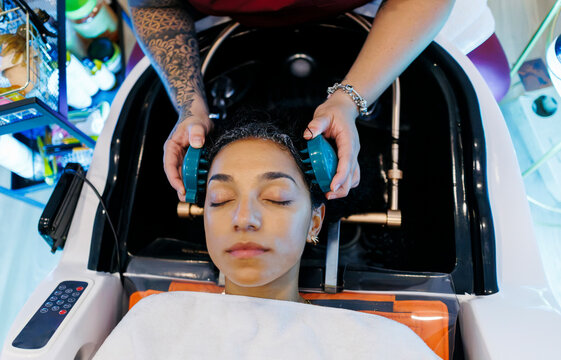 Woman enjoying professional hair care and relaxing scalp treatment