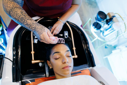 Professional giving relaxing scalp massage at salon