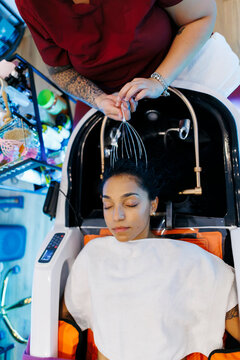 Woman enjoying relaxing head massage in salon chair