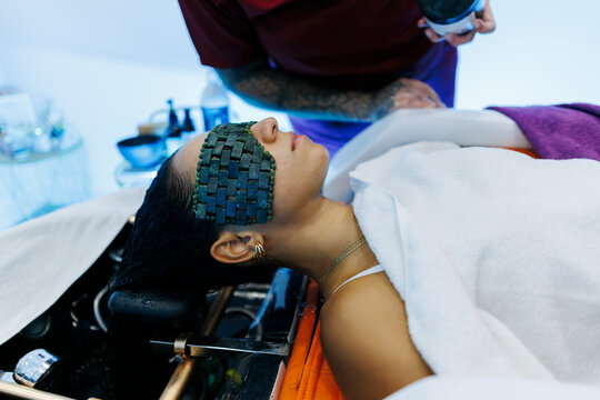 Woman enjoying relaxing beauty spa treatment with jade eye mask