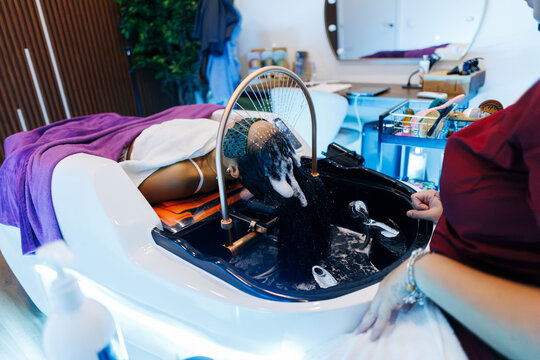 Woman getting hair washed at modern beauty salon