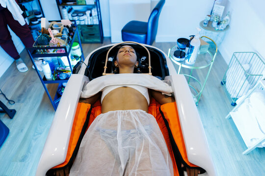 Woman relaxing in modern spa wellness treatment capsule