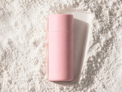 Pink matte cosmetic bottle mockup on white powder texture