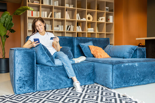 Long-haired woman with a phone and a credit card in hands