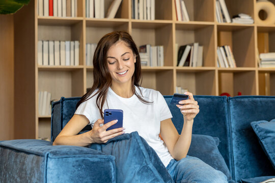 Young woman buying something online and looking contented