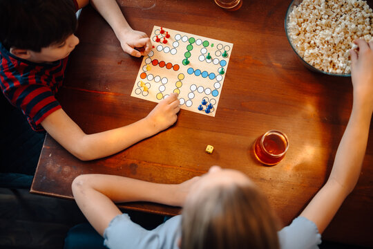 Children playing board game with popcorn and drinks