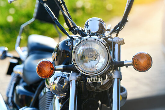 Minsk, Belarus. May 21, 2026. Classic Yamaha cruiser motorcycle, round chrome headlight and orange turn signals parked outdoors on sunny day with blurred background